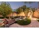 Landscaped backyard featuring stone and turf, with a wooden bridge over a charming water feature at 12955 E Mercer Ln, Scottsdale, AZ 85259