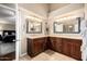 Bathroom featuring double vanities with warm cabinets and neutral countertops, alongside a view into the bedroom at 12955 E Mercer Ln, Scottsdale, AZ 85259