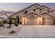 Two-story home with a three-car garage and desert landscaping at dusk at 12955 E Mercer Ln, Scottsdale, AZ 85259