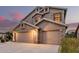 Lovely home with a three-car garage and warm exterior lighting at dusk at 12955 E Mercer Ln, Scottsdale, AZ 85259