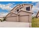 Side view of a two-story home featuring a three car garage and desert landscaping at 12955 E Mercer Ln, Scottsdale, AZ 85259