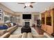 Cozy living room featuring a stone fireplace, hardwood floors, neutral tones, and comfortable seating at 12955 E Mercer Ln, Scottsdale, AZ 85259