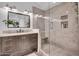 Modern bathroom featuring a glass-enclosed shower, marble details, and a dark vanity at 14446 N 40Th Pl, Phoenix, AZ 85032