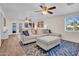 Spacious living room with a large sectional sofa, ceiling fans, and bright windows at 14446 N 40Th Pl, Phoenix, AZ 85032