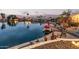 Evening shot of a lakefront patio with boat, string lights, and lush desert landscaping at 1453 E Butler Cir, Chandler, AZ 85225