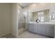 Modern bathroom featuring double sink vanity, glass enclosed shower, and neutral color palette at 15580 S 181St Ln, Goodyear, AZ 85338