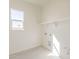 Bright laundry room featuring tile floors, a window, utility connections, and a shelf at 15580 S 181St Ln, Goodyear, AZ 85338