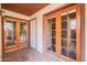 Covered patio with decorative cement flooring and glass paneled double doors to the interior at 16402 N 31St St # 115, Phoenix, AZ 85032