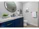 Charming bathroom featuring a blue vanity, a round mirror, and stylish fixtures at 16413 N Orchard Hills Dr, Sun City, AZ 85351