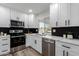 Updated kitchen with black backsplash, white cabinets, and stainless steel appliances at 16413 N Orchard Hills Dr, Sun City, AZ 85351