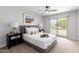 Bright main bedroom featuring a ceiling fan and sliding glass door to the outdoor space at 16413 N Orchard Hills Dr, Sun City, AZ 85351