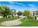 Lush green common area in the community, featuring mature trees, a paved walkway, and inviting landscaping at 16875 N 12Th St # 3, Phoenix, AZ 85022