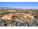 A scenic aerial view of the clubhouse showcasing a manicured golf course and neighboring homes against a clear blue sky at 16945 W Vernon Ave, Goodyear, AZ 85395