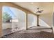 A covered patio with brick flooring, neutral walls, ceiling fan, and sun shades at 16945 W Vernon Ave, Goodyear, AZ 85395