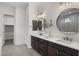 Well-lit bathroom with dual sinks, dark cabinetry, and a separate area with shower at 18007 N 66Th Way, Phoenix, AZ 85054