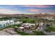 Aerial view of a brick home with circular driveway, complemented by lush greenery, a serene lake, and mountain views at 18178 W Desert View Ln, Goodyear, AZ 85338