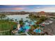 An aerial view features a resort style pool and waterpark surrounded by lush palms and desert landscaping at 18178 W Desert View Ln, Goodyear, AZ 85338