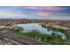 An aerial view showcases a scenic lake surrounded by lush greenery, community amenities, and residential areas at 18178 W Desert View Ln, Goodyear, AZ 85338