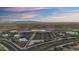 An aerial view of a commercial area surrounded by desert landscape, mountains, and roads with palm trees at 18178 W Desert View Ln, Goodyear, AZ 85338