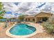 Backyard featuring a private pool and spa, desert landscaping, and a covered patio for outdoor dining at 18178 W Desert View Ln, Goodyear, AZ 85338