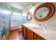 Bathroom featuring a double vanity, marine-themed wall art, walk-in shower, and wood-look flooring at 18178 W Desert View Ln, Goodyear, AZ 85338