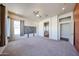 Spacious main bedroom with neutral carpet, ceiling fan, and view to the ensuite bathroom at 18178 W Desert View Ln, Goodyear, AZ 85338