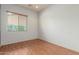 An empty bedroom with hardwood floors and a window with blinds to let in natural light at 18178 W Desert View Ln, Goodyear, AZ 85338