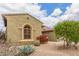 A beautiful, neutral-colored single-story home with attractive desert landscaping and mature trees in front at 18178 W Desert View Ln, Goodyear, AZ 85338