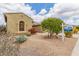 A beautiful, neutral-colored single-story home with attractive desert landscaping and mature trees in front at 18178 W Desert View Ln, Goodyear, AZ 85338