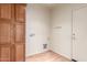 Functional laundry room with laminate flooring, ample cabinet storage, and hook rack at 18178 W Desert View Ln, Goodyear, AZ 85338