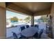 Covered patio with outdoor furniture overlooking a lush backyard with a pool at 18178 W Desert View Ln, Goodyear, AZ 85338