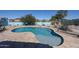 An inviting backyard pool with a baja shelf is surrounded by desert landscaping and a blue privacy wall at 18178 W Desert View Ln, Goodyear, AZ 85338