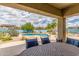 View of the private pool and patio area from the covered porch with outdoor table and chairs at 18178 W Desert View Ln, Goodyear, AZ 85338