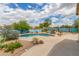 A kidney-shaped swimming pool is surrounded by desert landscaping and a blue fence in the backyard at 18178 W Desert View Ln, Goodyear, AZ 85338