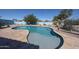 An inviting backyard pool with a baja shelf is surrounded by desert landscaping and a blue privacy wall at 18178 W Desert View Ln, Goodyear, AZ 85338