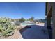 A backyard features a sparkling pool, a large patio, and desert landscaping with cacti under a clear blue sky at 18178 W Desert View Ln, Goodyear, AZ 85338