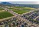 Beautiful aerial view featuring the community, adjacent farmland, and mountains in the distance at 18436 E Celtic Manor Dr, Queen Creek, AZ 85142