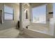 Bright bathroom with a soaking tub, neutral color palette, and natural light from the window at 18436 E Celtic Manor Dr, Queen Creek, AZ 85142