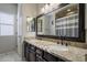 Bathroom vanity with granite countertop, double sinks, and large framed mirror at 18436 E Celtic Manor Dr, Queen Creek, AZ 85142