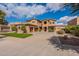 Attractive exterior featuring three-car garage, manicured lawn, and inviting curb appeal under a clear blue sky at 18436 E Celtic Manor Dr, Queen Creek, AZ 85142