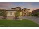 Stunning home with manicured lawn and landscape bathed in the warm glow of the evening sunset at 18436 E Celtic Manor Dr, Queen Creek, AZ 85142