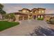 Inviting two-story home showcasing a spacious driveway, lush landscaping and a three-car garage at 18436 E Celtic Manor Dr, Queen Creek, AZ 85142