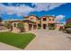 Impressive exterior of a well-maintained home with a spacious driveway and manicured lawn under a clear blue sky at 18436 E Celtic Manor Dr, Queen Creek, AZ 85142