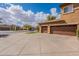 Expansive driveway leads to the attached garage of this well-maintained home with manicured lawn at 18436 E Celtic Manor Dr, Queen Creek, AZ 85142