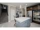 Modern kitchen featuring an island with white countertops, dark cabinets, and stainless steel appliances for cooking convenience at 18436 E Celtic Manor Dr, Queen Creek, AZ 85142