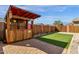 Backyard with a custom outdoor bar, artificial grass, and manicured landscaping at 18502 N Celis St, Maricopa, AZ 85138