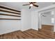 Bedroom showcasing a ceiling fan, wood-look floors, and custom wood shelving, creating a cozy and organized atmosphere at 18502 N Celis St, Maricopa, AZ 85138