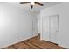 Bright bedroom featuring wood look laminate flooring, ceiling fan, and closet with doors at 18502 N Celis St, Maricopa, AZ 85138