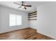 Bright bedroom with hardwood floors, ceiling fan, and a large window for plenty of natural light at 18502 N Celis St, Maricopa, AZ 85138