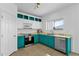 Bright kitchen features stainless steel appliances, and white and teal cabinets, combining style and functionality at 18502 N Celis St, Maricopa, AZ 85138